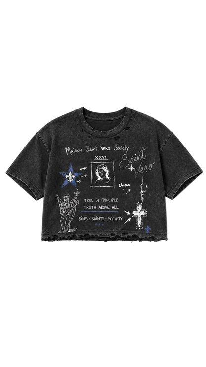A black mineral-wash cropped t-shirt with white and blue graphic prints related to Saint Vincent, displayed flat against a light gray background.